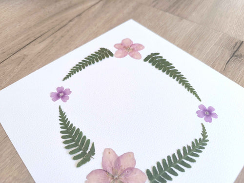 Cadre de fleurs séchées et fougères sur papier blanc, décoration naturelle artisanale